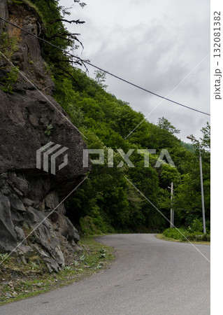 Turn of the road near a cliff on the background of mountains Turn of the road near a cliff on the background of mountains 132081382