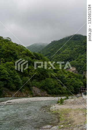 Thick clouds over the mountains, a river between the mountains, Georgia 132081384