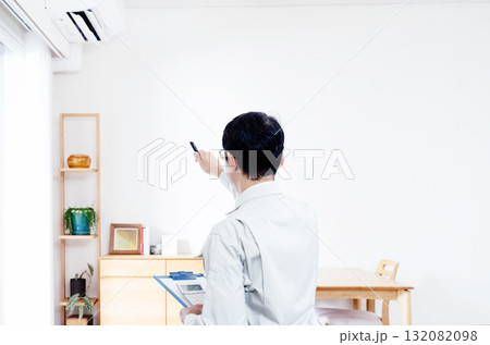 エアコンの動作確認をする作業服の男性 132082098