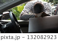 Masked thief reaching into a car to steal valuable items, view from inside the vehicle. Concept of crime, car theft, danger, security risk, and prevention awareness for property and vehicle protection 132082923