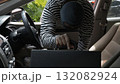 Masked thief stealing a briefcase from inside a car, symbolizing crime, theft, and loss. Concept of security awareness, vehicle safety, and prevention of property theft in daily urban environments 132082924