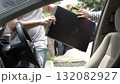thief violently snatching a briefcase from a driver through a car door, showing the moment of a car robbery in broad daylight. Concept of danger, theft, urban crime, security risk, and safety 132082927