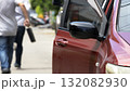 open car door with a man walking away holding a briefcase after a robbery, concept of crime, danger, theft, and security awareness. Represents the aftermath of a carjacking or street crime situation 132082930