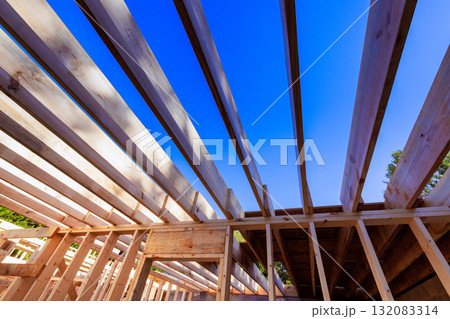 Workers are constructing wooden beams framework for new building Workers are constructing wooden beams framework for new building 132083314