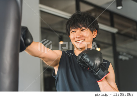 ジム,トレーニングジムでサンドバックをパンチするをする若いアジア人男性 ジム,トレーニングジムでサンドバックをパンチするをする若いアジア人男性 132083868