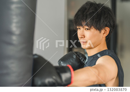 ジム,トレーニングジムでサンドバックをパンチするをする若いアジア人男性 ジム,トレーニングジムでサンドバックをパンチするをする若いアジア人男性 132083870