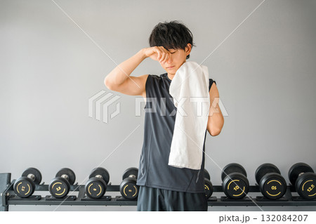 トレーニングジムにいるスポーツウェア姿の若いアジア人男性(疲れ,オーバーワーク) トレーニングジムにいるスポーツウェア姿の若いアジア人男性(疲れ,オーバーワーク) 132084207