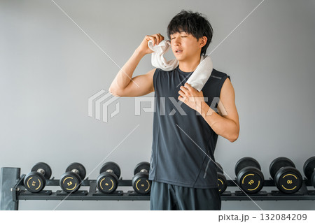 トレーニングジムにいるスポーツウェア姿の若いアジア人男性(疲れ,オーバーワーク) トレーニングジムにいるスポーツウェア姿の若いアジア人男性(疲れ,オーバーワーク) 132084209