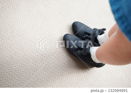 黒いリボン付きシューズを履いた子どもの足元の写真 132084891