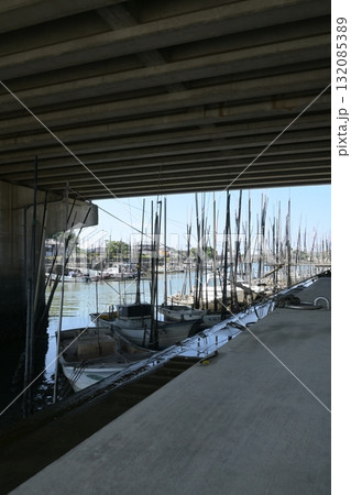 橋の下に係留された小さな漁船と長い係留杭 132085389