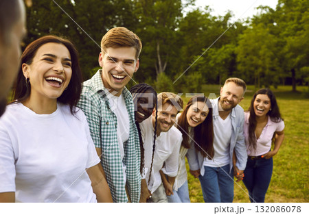Portrait of friends having fun and laughing while walking in park on warm summer day. 132086078
