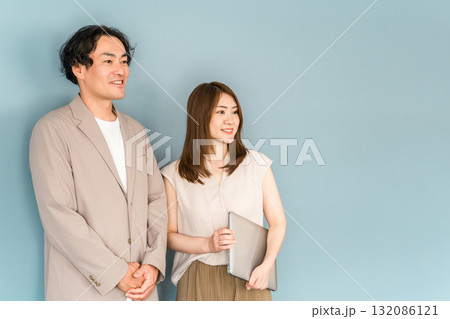 オフィスでノートパソコンを持って立つ男女のビジネスマン 132086121