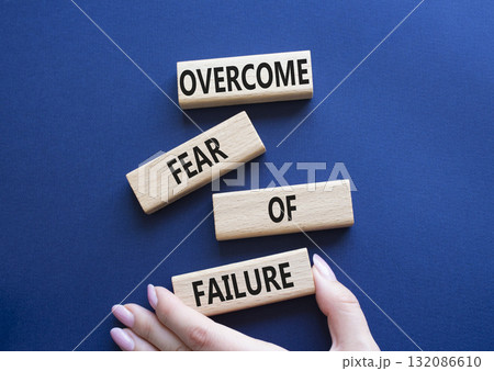 Fear of failure symbol. Concept words Overcome Fear of failure on wooden blocks. Beautiful deep blue background. Businessman hand. Business and Fear of failure concept. Copy space. 132086610