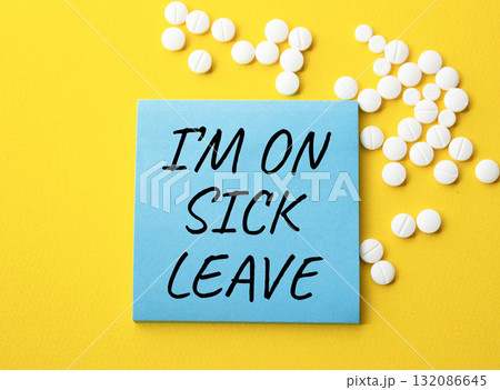 Sick leave symbol. Concept word I am on sick leave on blue note. Beautiful yellow background with pills. Medicine and I am on sick leave concept. Copy space 132086645