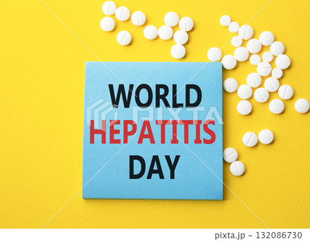 World Hepatitis Day symbol. Concept words World Hepatitis Day on blue note. Beautiful yellow background with pills. Healthcare and World Hepatitis Day concept. Copy space. World Hepatitis Day symbol. Concept words World Hepatitis Day on blue note. Beautiful yellow background with pills. Healthcare and World Hepatitis Day concept. Copy space. 132086730