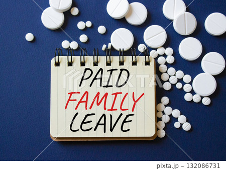 Paid Family Leave symbol. Concept words Paid Family Leave on notebook. Beautiful deep blue background with pills. Healthcare and Paid Family Leave concept. Copy space. 132086731