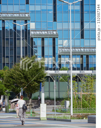 夏の朝の金沢駅西広場を渡る通勤中の若い女性会社員の姿	 132087144