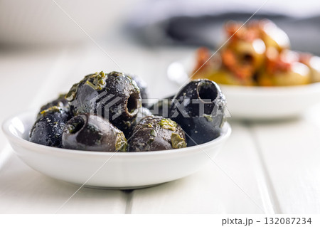 Tapas. Flavored pickled olives in bowl on white table. Tapas. Flavored pickled olives in bowl on white table. 132087234