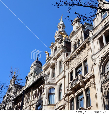 Ornate facade of historic building in Antwerp, Belgium, featuring sculptures and architectural details under blue sky Ornate facade of historic building in Antwerp, Belgium, featuring sculptures and architectural details under blue sky 132087673