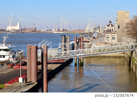 Scheldt river with ferry pier, gangway, and wind turbines, Antwerp port industrial landscape. Belgium Scheldt river with ferry pier, gangway, and wind turbines, Antwerp port industrial landscape. Belgium 132087674