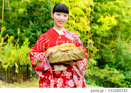 贈答品を手に持つ振袖姿の女性 132088392