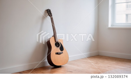 Acoustic Guitar Leaning Against White Wall in Minimalist Interior for Lifestyle Photography Acoustic Guitar Leaning Against White Wall in Minimalist Interior for Lifestyle Photography 132089374