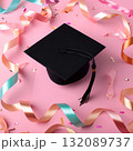 Graduation cap placed on a vibrant pink background surrounded by colorful ribbons and confetti, symbolizing celebration and achievement in education 132089737