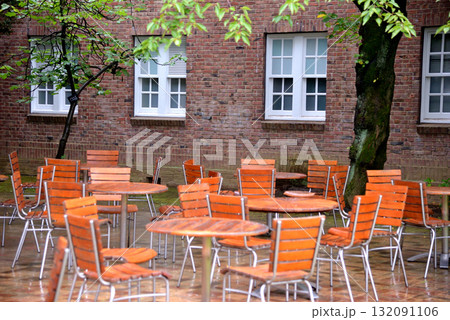 雨の日のキャンパスで濡れるテーブルとイス 132091106