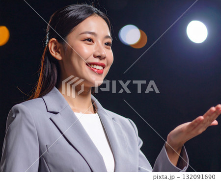 手を差し出して案内をする若い女性 132091690