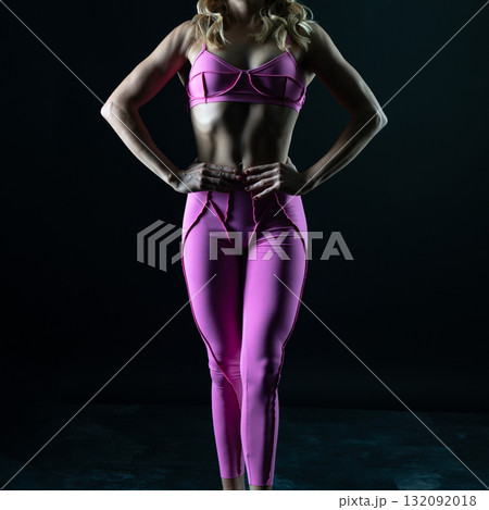 athletic female body in pink sportswear on dark background, fitness woman, athletic girl torso athletic female body in pink sportswear on dark background, fitness woman, athletic girl torso 132092018