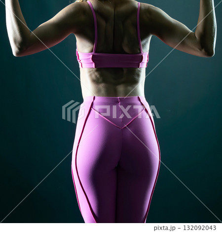 athletic female body in pink sportswear on dark background, fitness woman, athletic girl torso athletic female body in pink sportswear on dark background, fitness woman, athletic girl torso 132092043