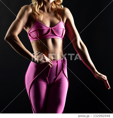 athletic female body in pink sportswear on dark background, fitness woman, athletic girl torso 132092048