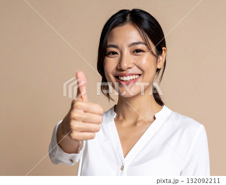親指を立てるポーズする若い女性 132092211