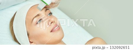Caucasian young female undergoing facial treatment in spa with ultrasonic skin Caucasian young female undergoing facial treatment in spa with ultrasonic skin 132092651