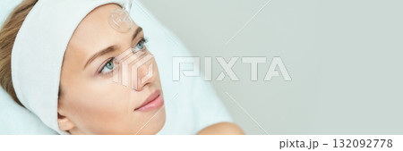 Young caucasian female receiving facial treatment with hydrogel patch in spa Young caucasian female receiving facial treatment with hydrogel patch in spa 132092778
