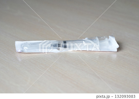 Sealed disposable syringe on wooden surface for medical and healthcare use 132093083
