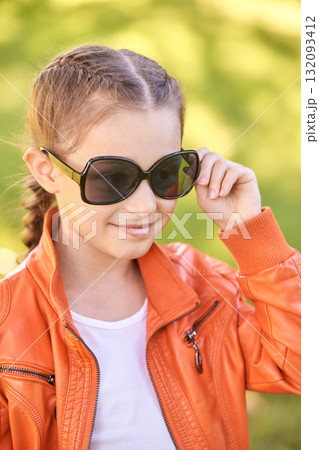 Young caucasian female child in orange jacket wearing sunglasses outdoors Young caucasian female child in orange jacket wearing sunglasses outdoors 132093412