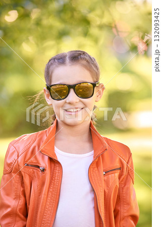 Smiling caucasian young girl in orange jacket and sunglasses outdoors on sunny Smiling caucasian young girl in orange jacket and sunglasses outdoors on sunny 132093425
