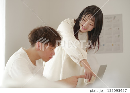 パソコンを見ながら話し合うカップル 132093437