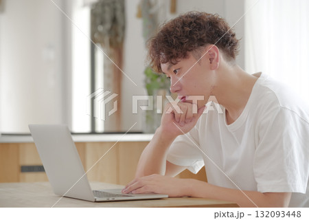 リビングでパソコン作業をする若い男性 132093448