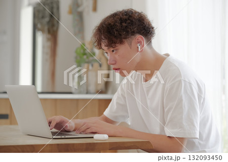 リビングでパソコン作業をする若い男性 132093450