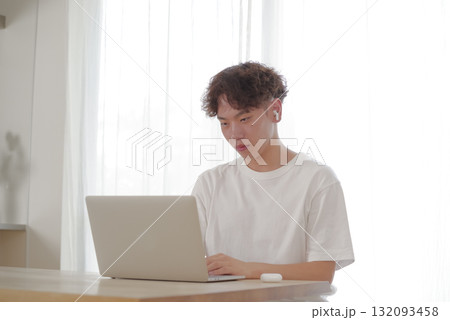 リビングでパソコン作業をする若い男性 132093458
