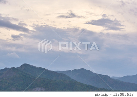 Serene cloudy sky over peaceful mountain range at dusk captured in tranquil 132093618