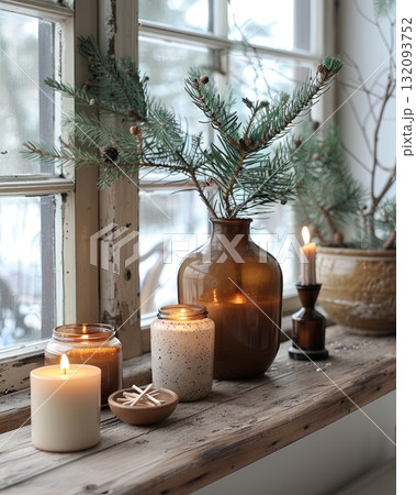 Cozy winter scene with candles, greenery, and decorative elements on a wooden windowsill Cozy winter scene with candles, greenery, and decorative elements on a wooden windowsill 132093752