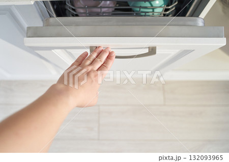 Caucasian female opening kitchen drawer with outstretched hand on white cabinet Caucasian female opening kitchen drawer with outstretched hand on white cabinet 132093965