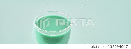 Close-up of a glass of fresh green smoothie with a minimalist background Close-up of a glass of fresh green smoothie with a minimalist background 132094047