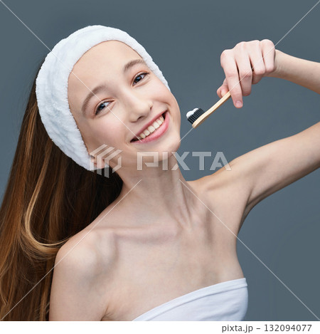 Smiling caucasian female teen with headband using bamboo toothbrush for oral Smiling caucasian female teen with headband using bamboo toothbrush for oral 132094077