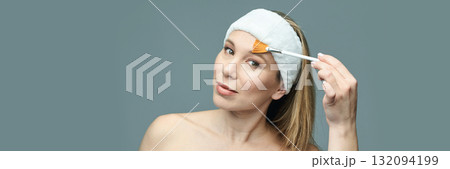 Caucasian female adult applying face mask with brush for skincare routine Caucasian female adult applying face mask with brush for skincare routine 132094199
