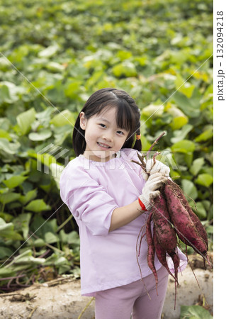 サツマイモを収穫するかわいい女の子 サツマイモを収穫するかわいい女の子 132094218