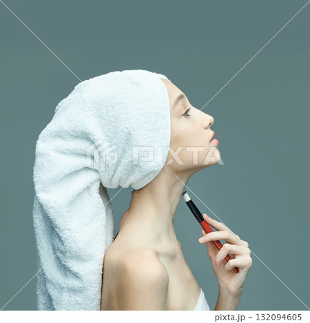 Young caucasian female relaxing with towel turban and applying makeup on neck Young caucasian female relaxing with towel turban and applying makeup on neck 132094605
